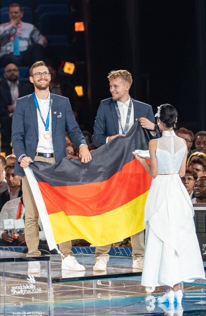Marc-Aurel Spalek und Lennard Weitzmann mit Bronzemedaille und Deutschlandfahne bei der Siegerehrung der WorldSkills 2026 in Shanghai
